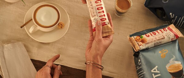 Hände reichen Giotto-Riegel bei Kaffee und Keksen