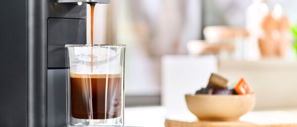 Kaffeemaschine füllt Glas mit Espresso