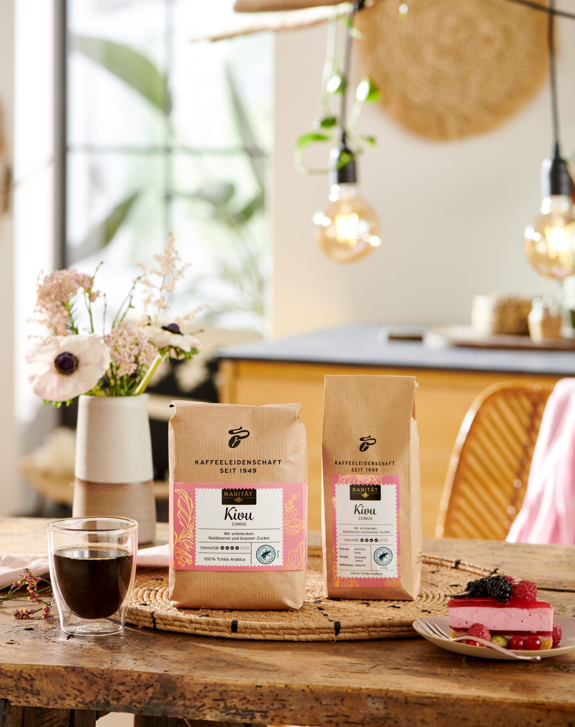 Kaffeebohnen, Glas Kaffee und Kuchen auf Holztisch