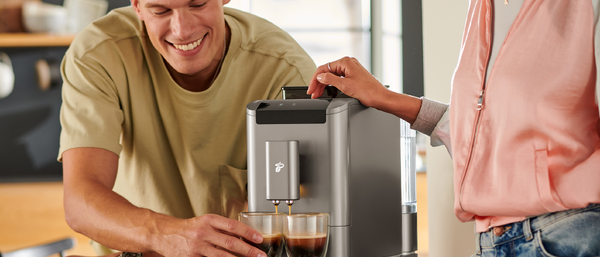 Zwei Personen bereiten Espresso am Vollautomaten zu