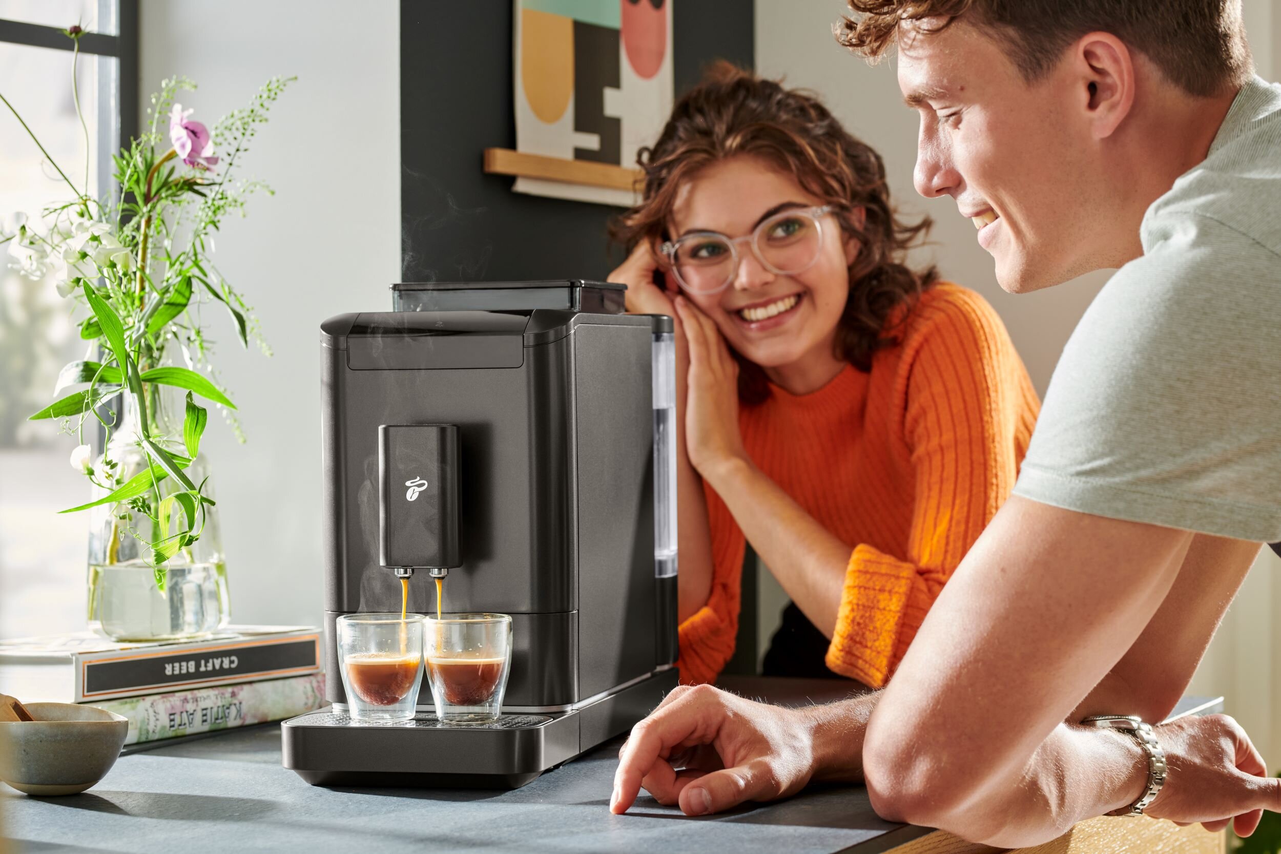 Zwei Personen beobachten eine Espressomaschine