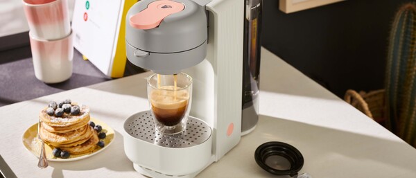 Kaffeemaschine brüht Espresso neben Pancakes