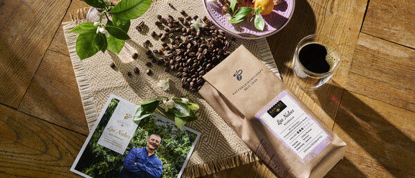 Kaffeebohnen, Kaffeepaket und Espresso auf Holztisch