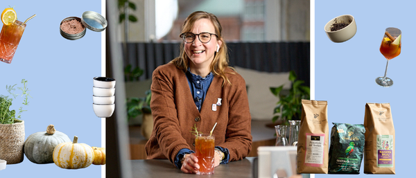 Person mit Drink, umgeben von Kaffee und Kürbissen