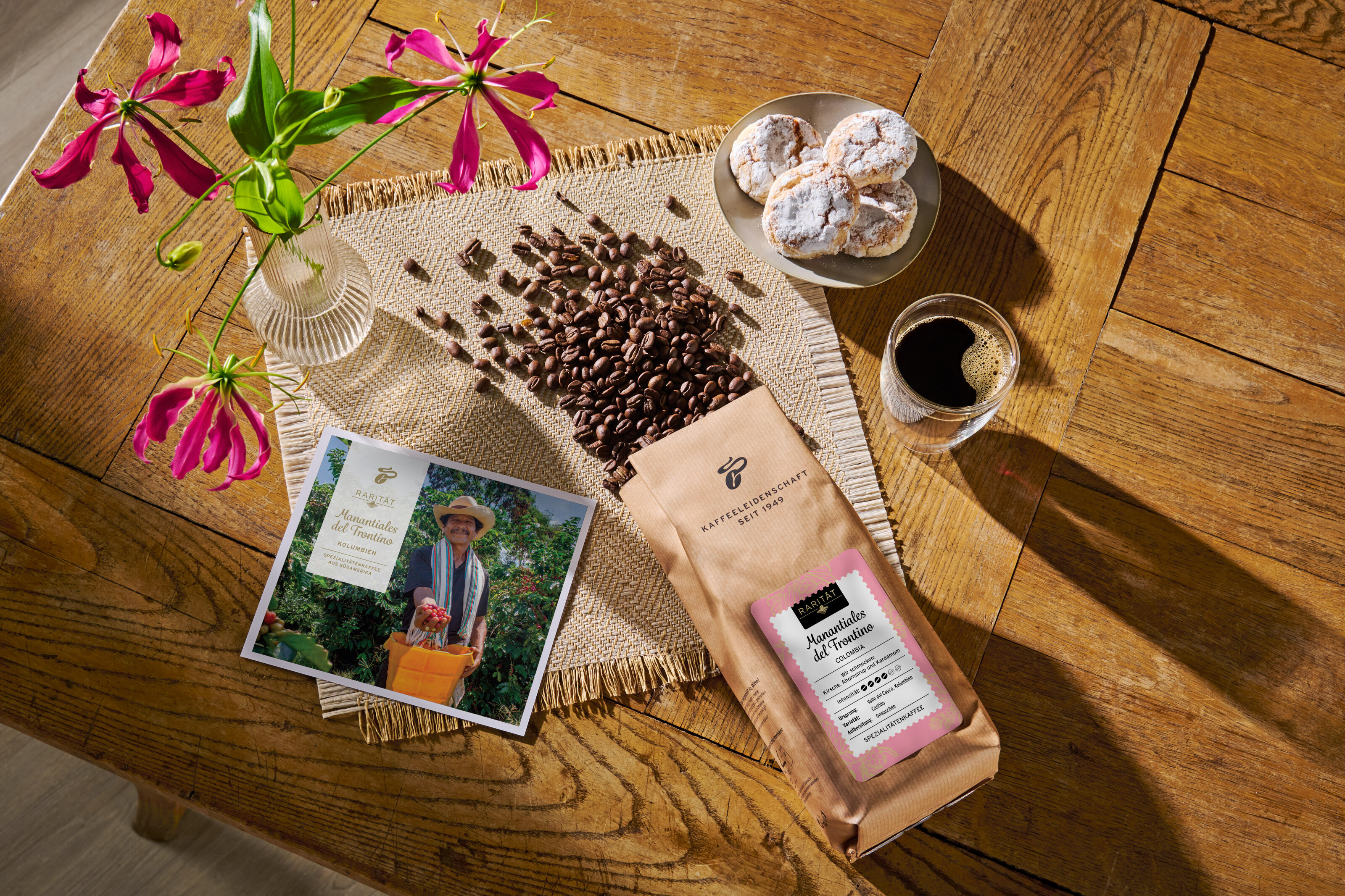 Kaffeetisch mit Bohnen, Tasse Espresso und Gebäck