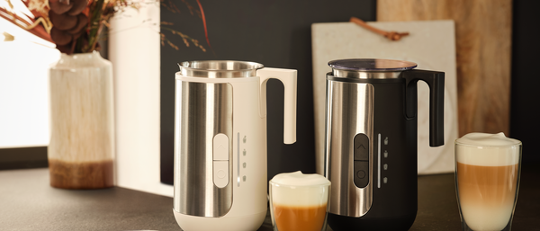 Zwei Milchaufschäumer mit zwei Gläsern Latte macchiato