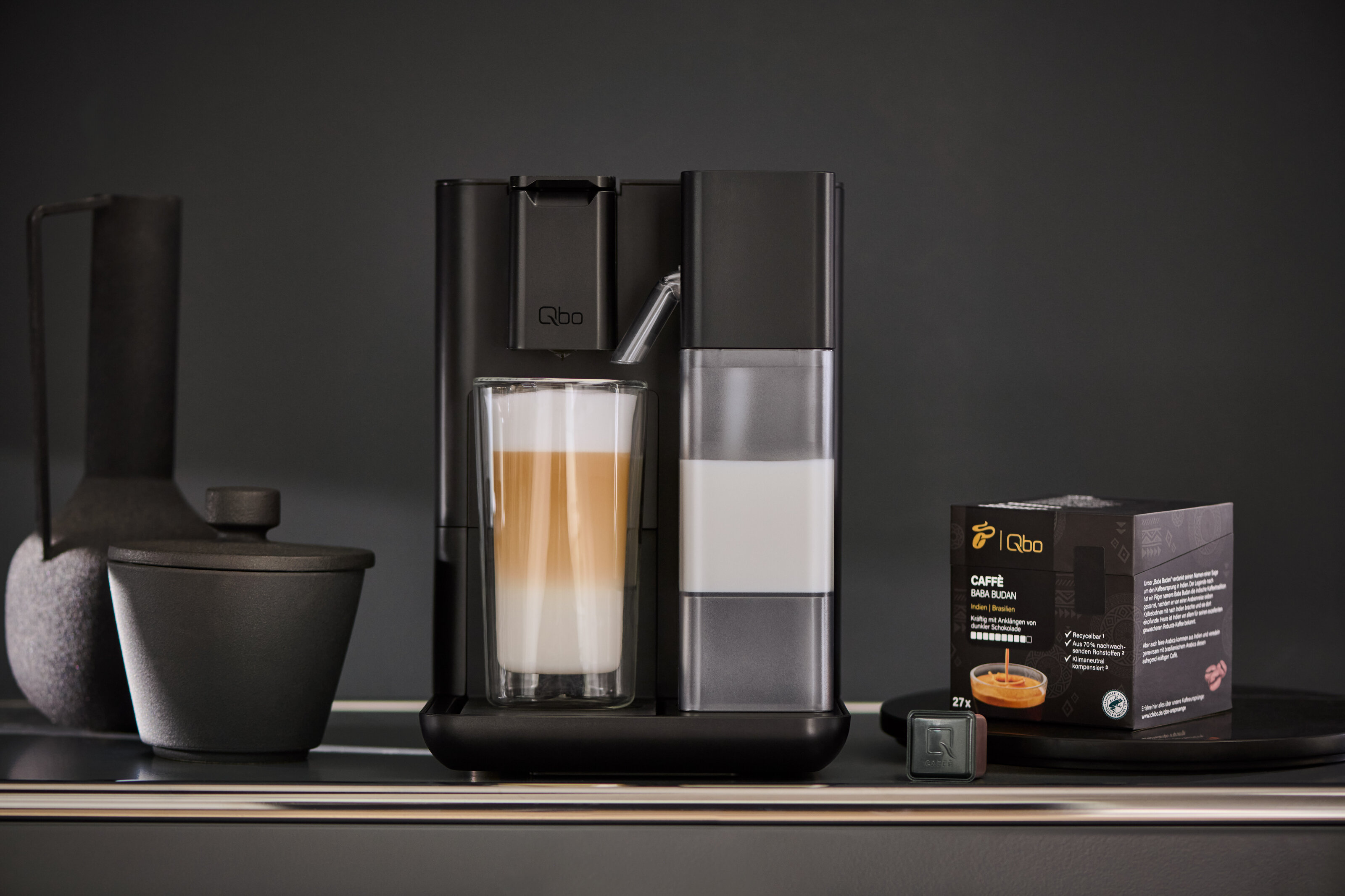 Moderne Kaffeemaschine mit Latte Macchiato und Kapseln