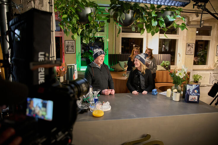 Menschen mit Wintermützen an Bartresen im Café