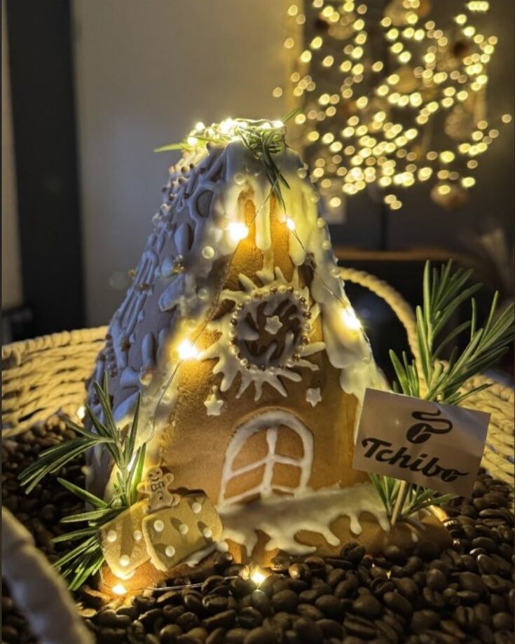 Lebkuchenhaus mit Lichterkette auf Kaffeebohnen