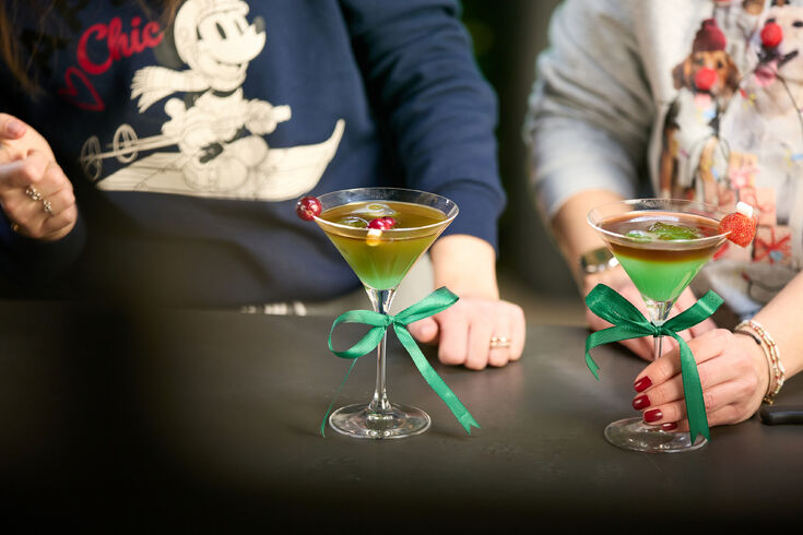 Zwei bunte Cocktails mit grünen Schleifen an Gläsern