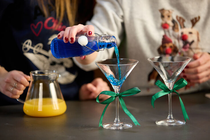 Blaue Flüssigkeit wird in Martini-Glas gegossen