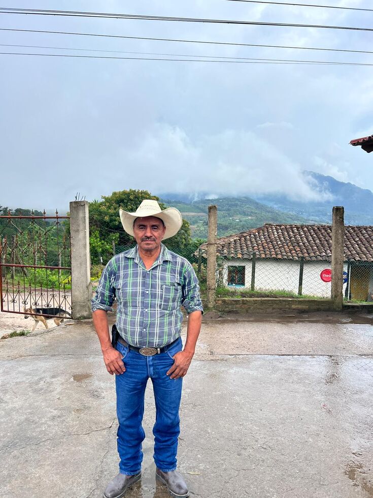Mann mit Cowboyhut vor nebligen Bergen