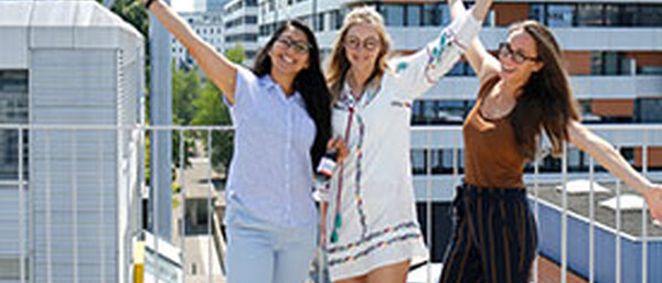 Drei fröhliche Frauen auf einer Dachterrasse