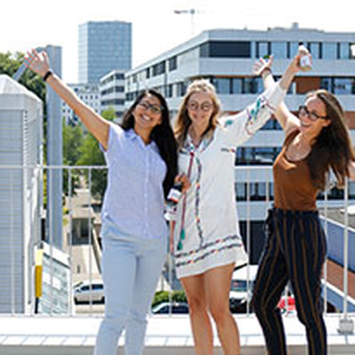 Drei fröhliche Frauen auf einer Dachterrasse