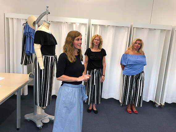 Drei Frauen und Puppe in gestreiften Röcken