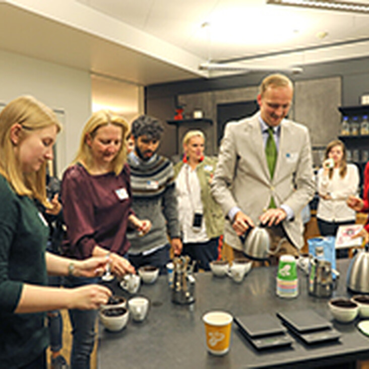 Menschen bereiten gemeinsam Kaffee in Küche zu
