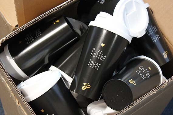 Karton voller schwarzer Becher mit Aufdruck „Coffee lover“