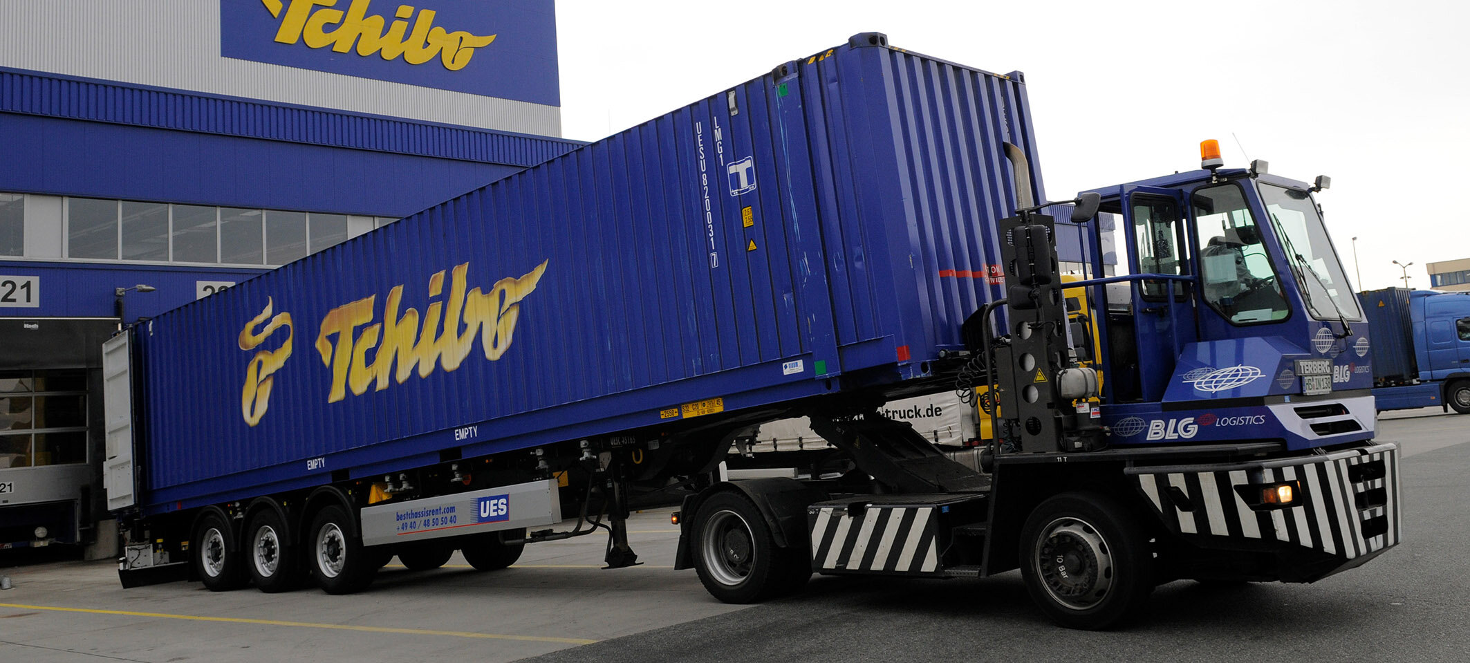 Blauer Tchibo-Container auf LKW vor Lagerhaus