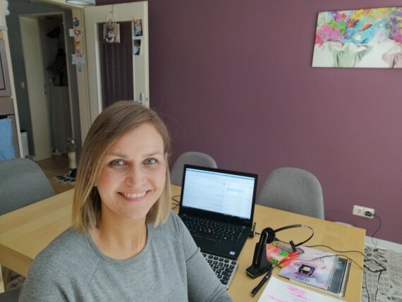 Frau im Homeoffice vor Laptop am Esstisch