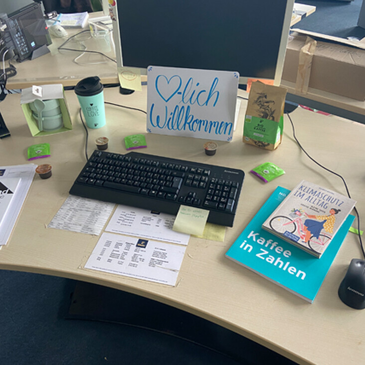 Schreibtisch mit Willkommensschild und Tastatur