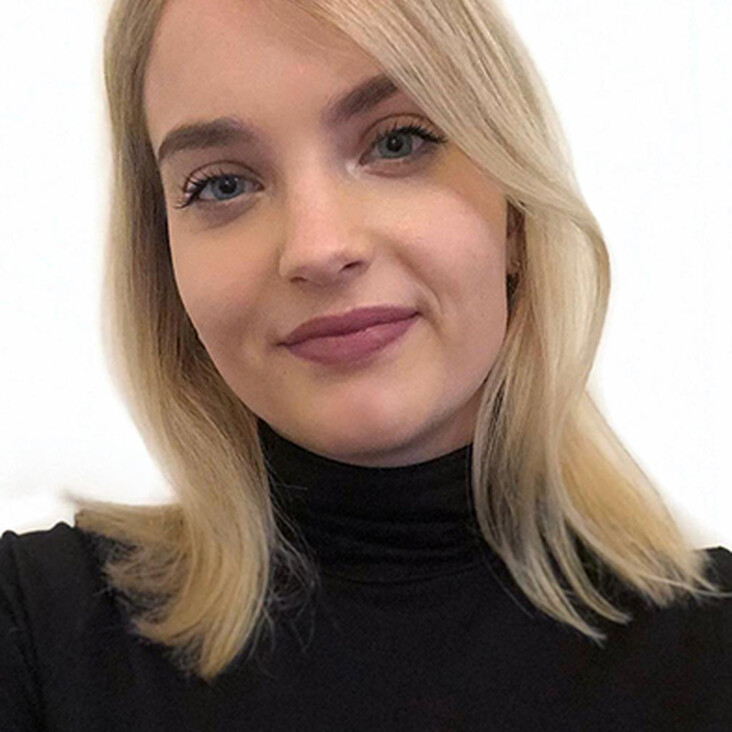 Person mit blondem Haar und schwarzem Rollkragenpullover