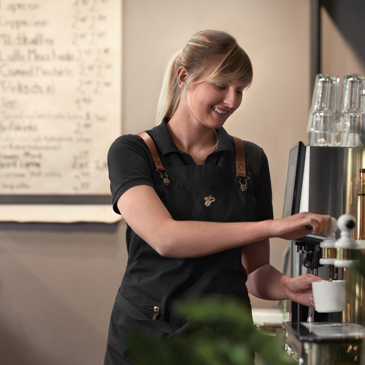 Barista bereitet Kaffee an Espressomaschine zu