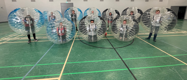 Menschen in Bubble-Suits in Sporthalle
