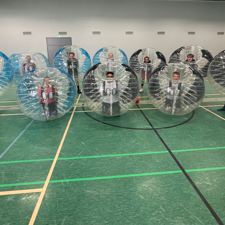 Menschen in Bubble-Suits in Sporthalle