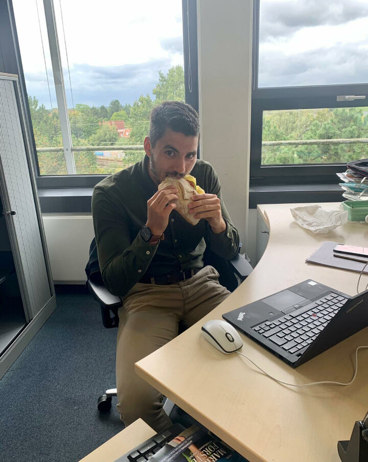 Person isst Wrap am Schreibtisch im Büro
