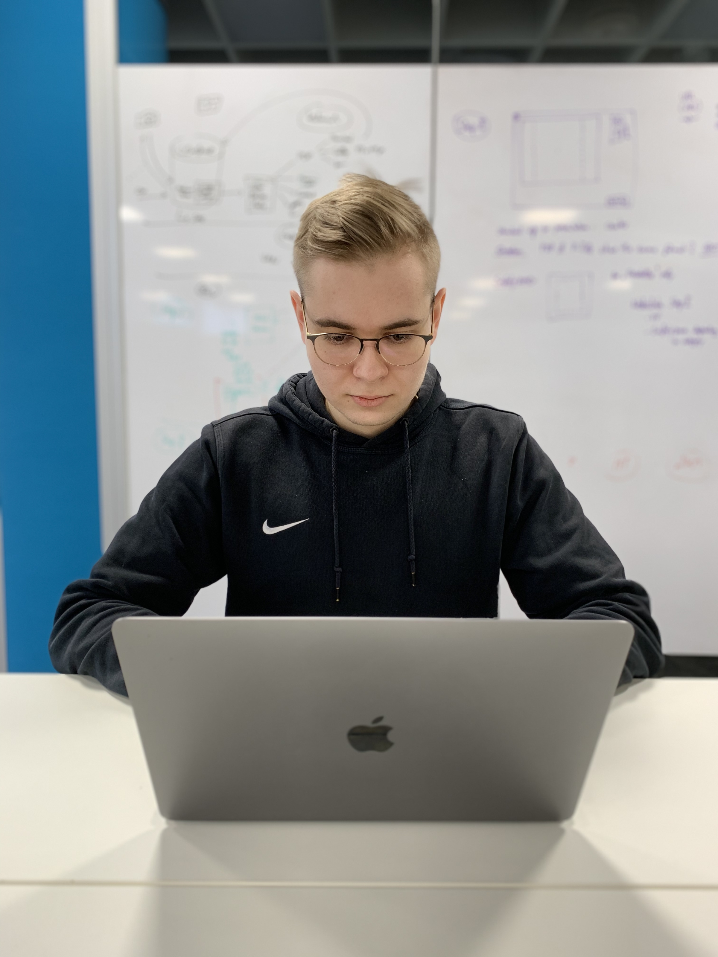 Person mit Laptop vor Whiteboard im Büro