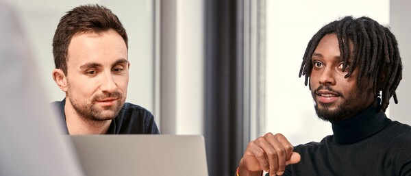 Zwei Personen im Büro vor einem Laptop