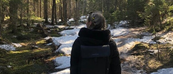 Person wandert auf schneebedecktem Waldweg
