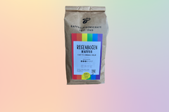 Kaffeepackung „Regenbogen Kaffee“ auf Pastellhintergrund