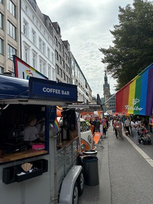 Link: Großansicht des Bildes - Bildinhalt: Straßenfest mit Coffee-Bar und Regenbogenfahnen