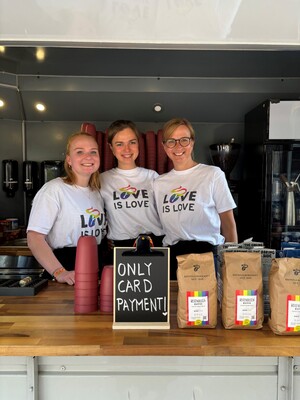 Link: Großansicht des Bildes - Bildinhalt: Drei Baristas mit „Love is Love“-Shirts am Kaffeestand