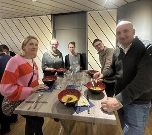 Link: Großansicht des Bildes - Bildinhalt: Gruppe isst Suppe an hohem Stehtisch