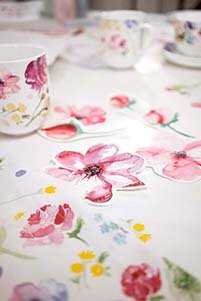 Tisch mit bunten Aquarellblumen und Tassen