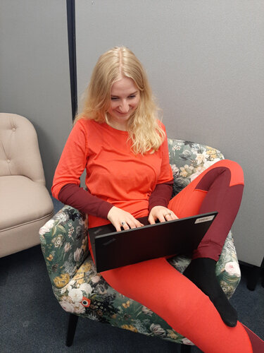 Person im Sessel arbeitet mit Laptop