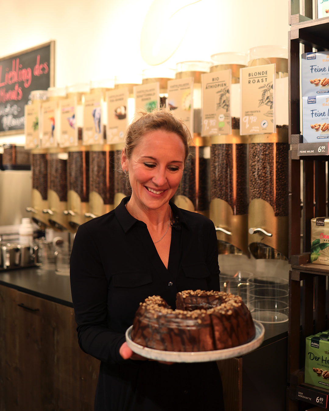 Frau im Café hält Schokokuchen mit Nüssen