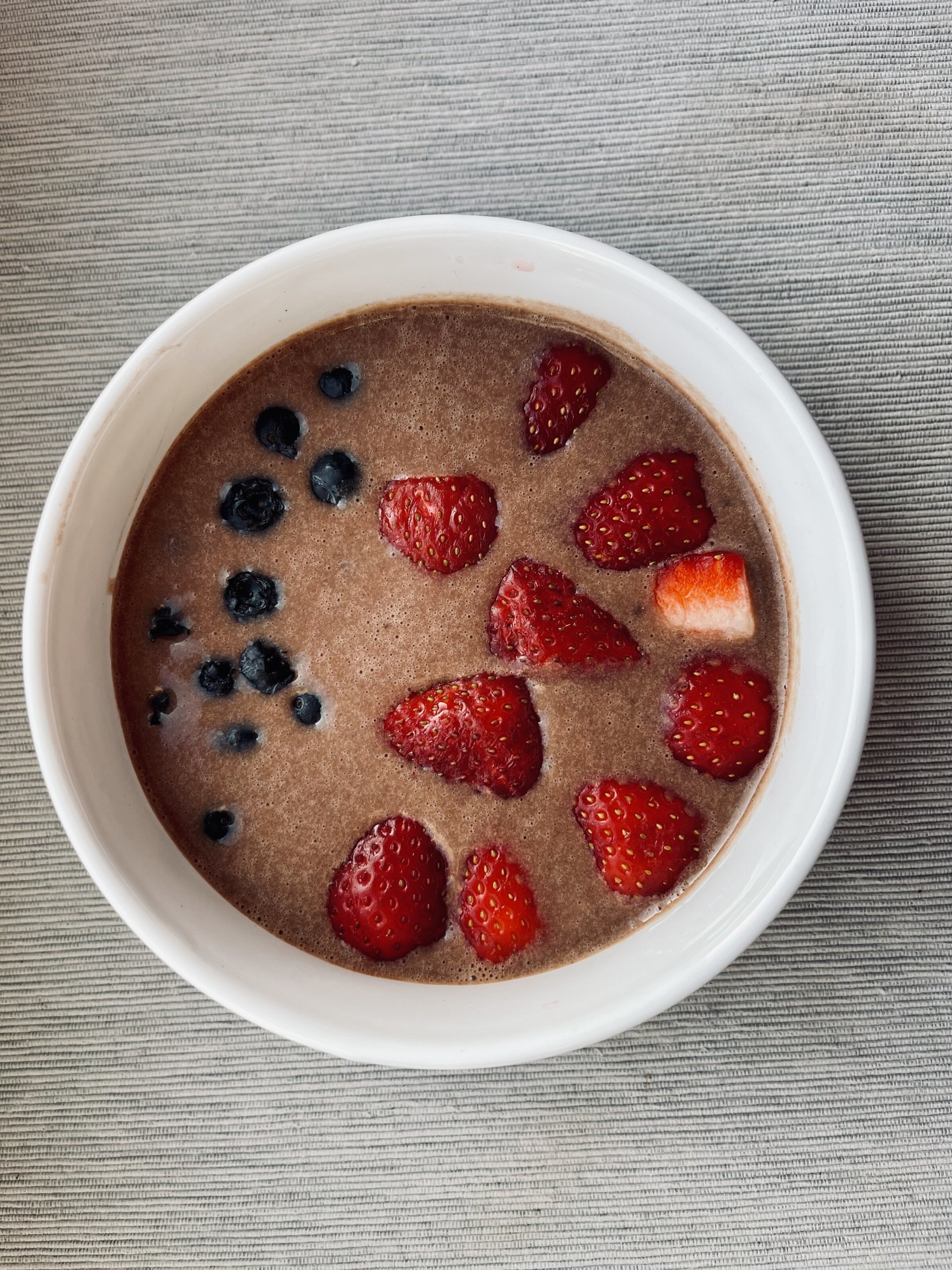 Schüssel Kakao-Porridge mit Erdbeeren und Heidelbeeren