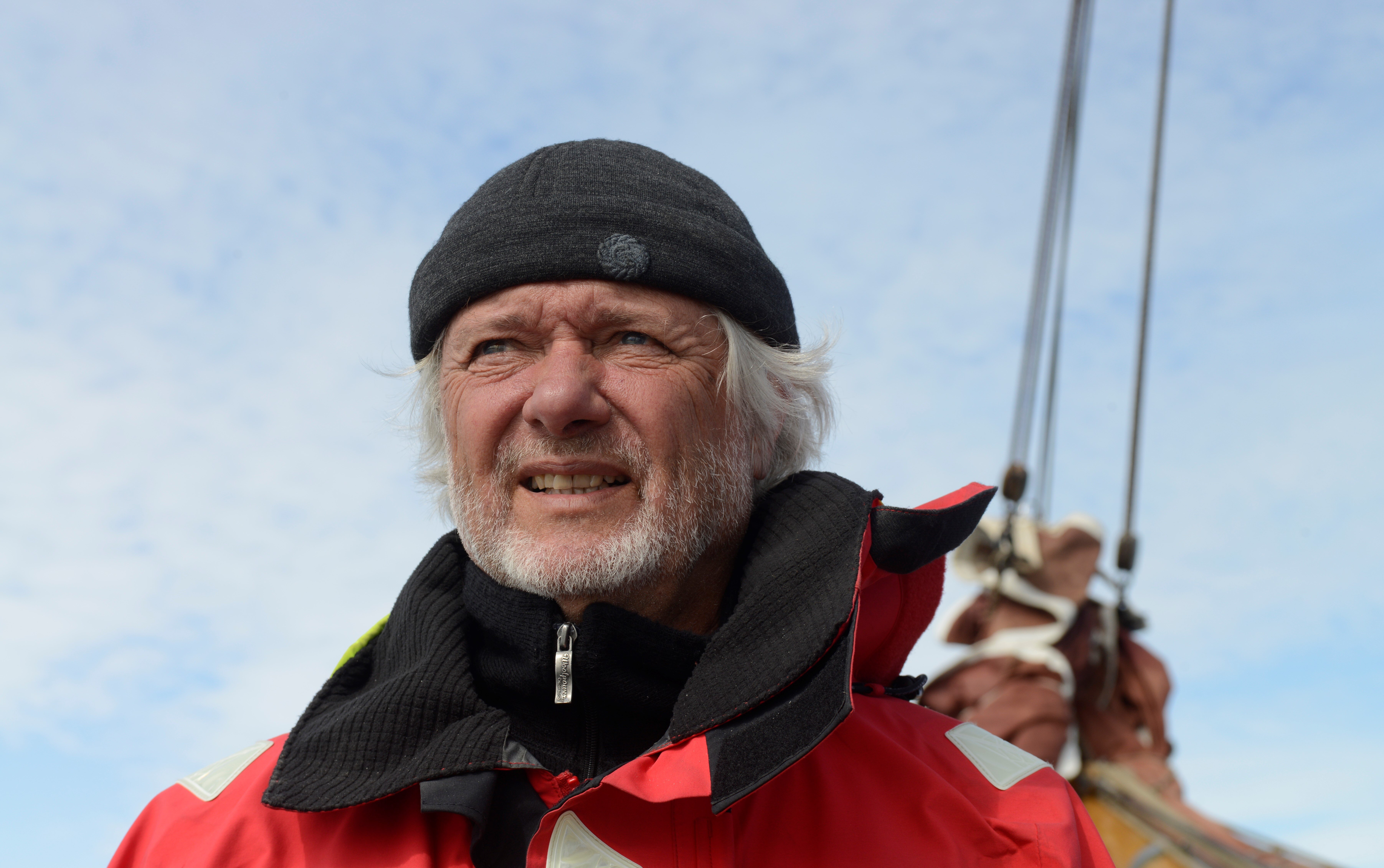 Person mit roter Segeljacke auf einem Boot