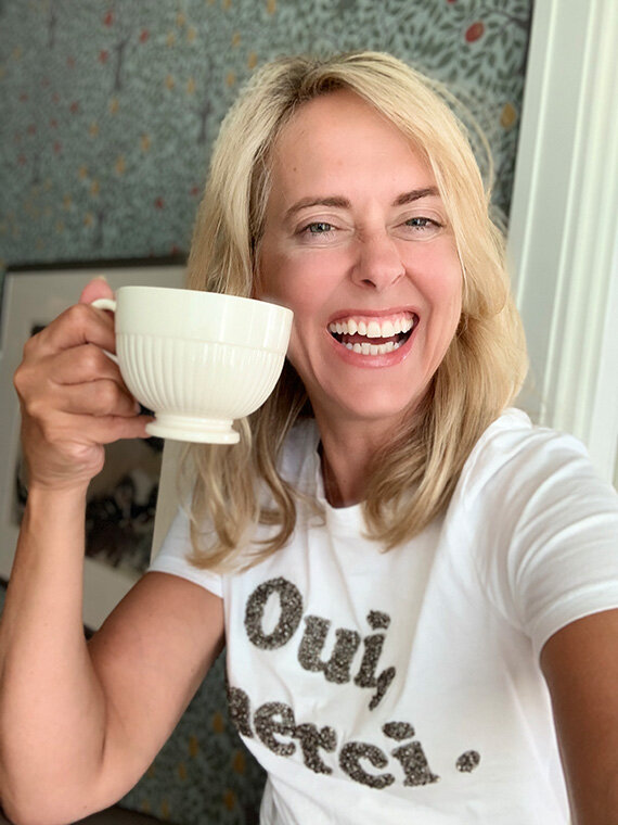 Person mit Tasse und T-Shirt „Oui, merci.“