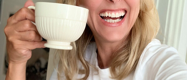 Person mit Tasse und T-Shirt „Oui, merci.“