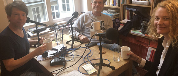 Drei Personen nehmen Podcast in Bücherzimmer auf