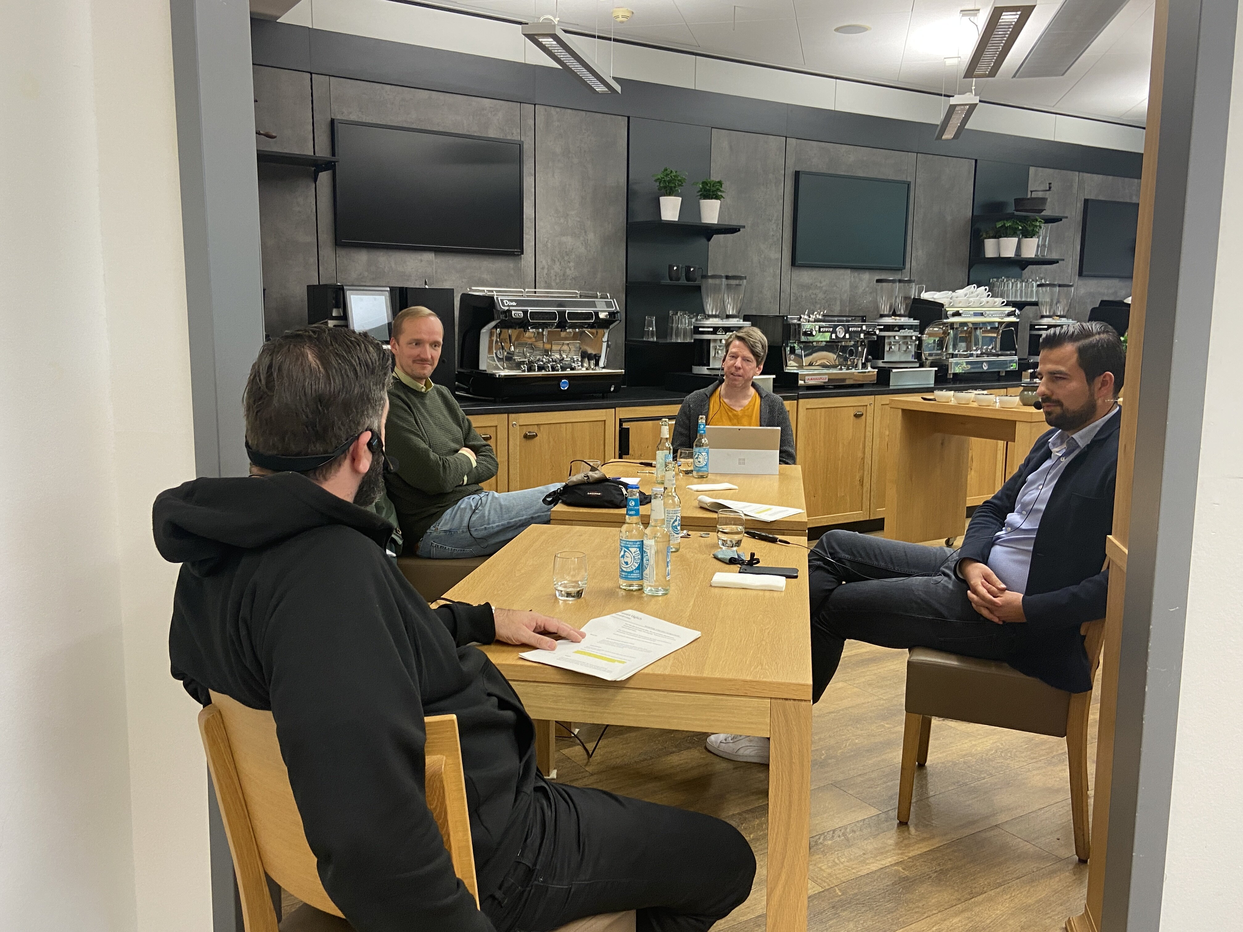 Vier Personen im Meeting in moderner Kaffeeküche