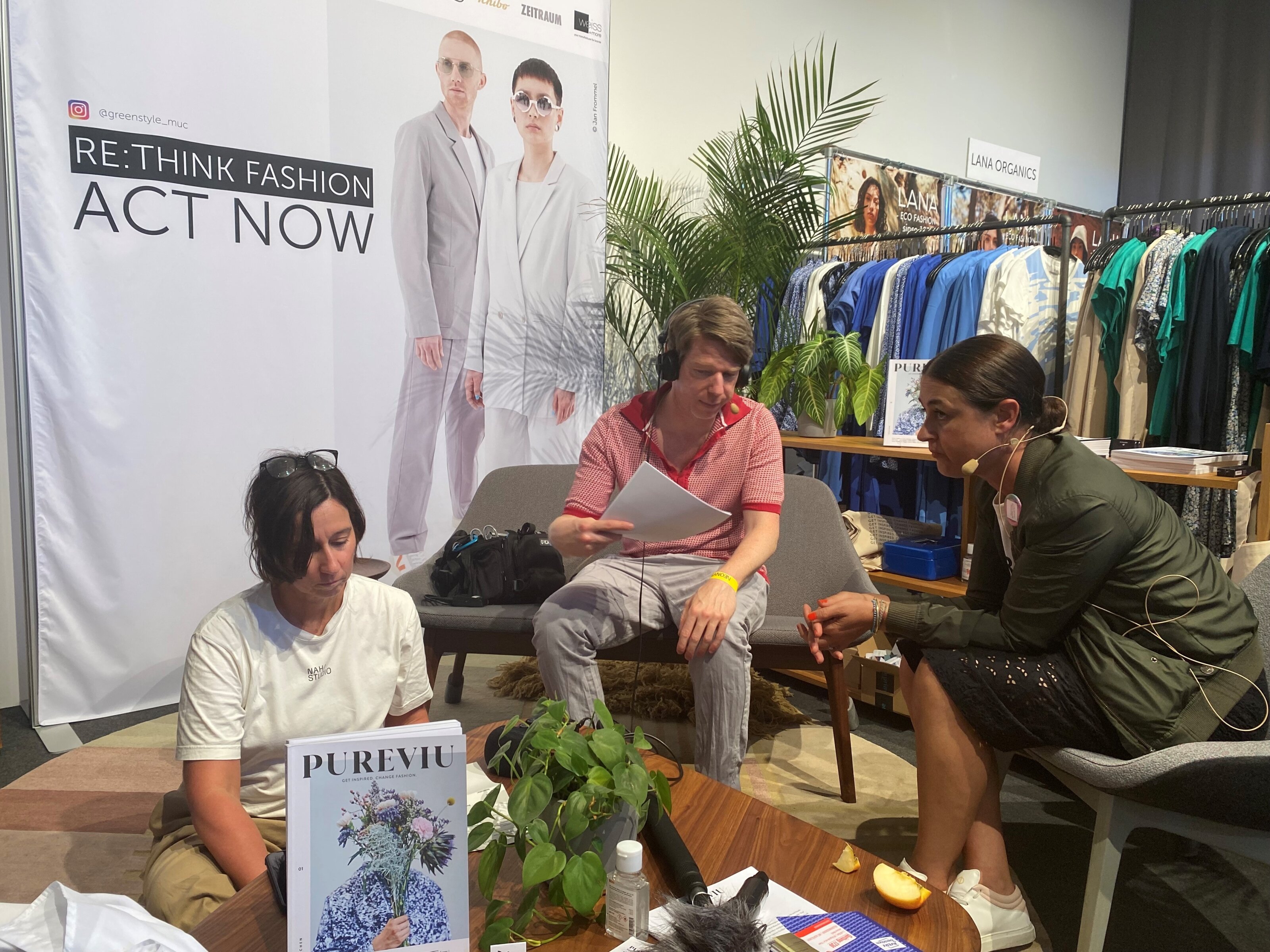 Drei Personen im Gespräch auf nachhaltiger Modemesse