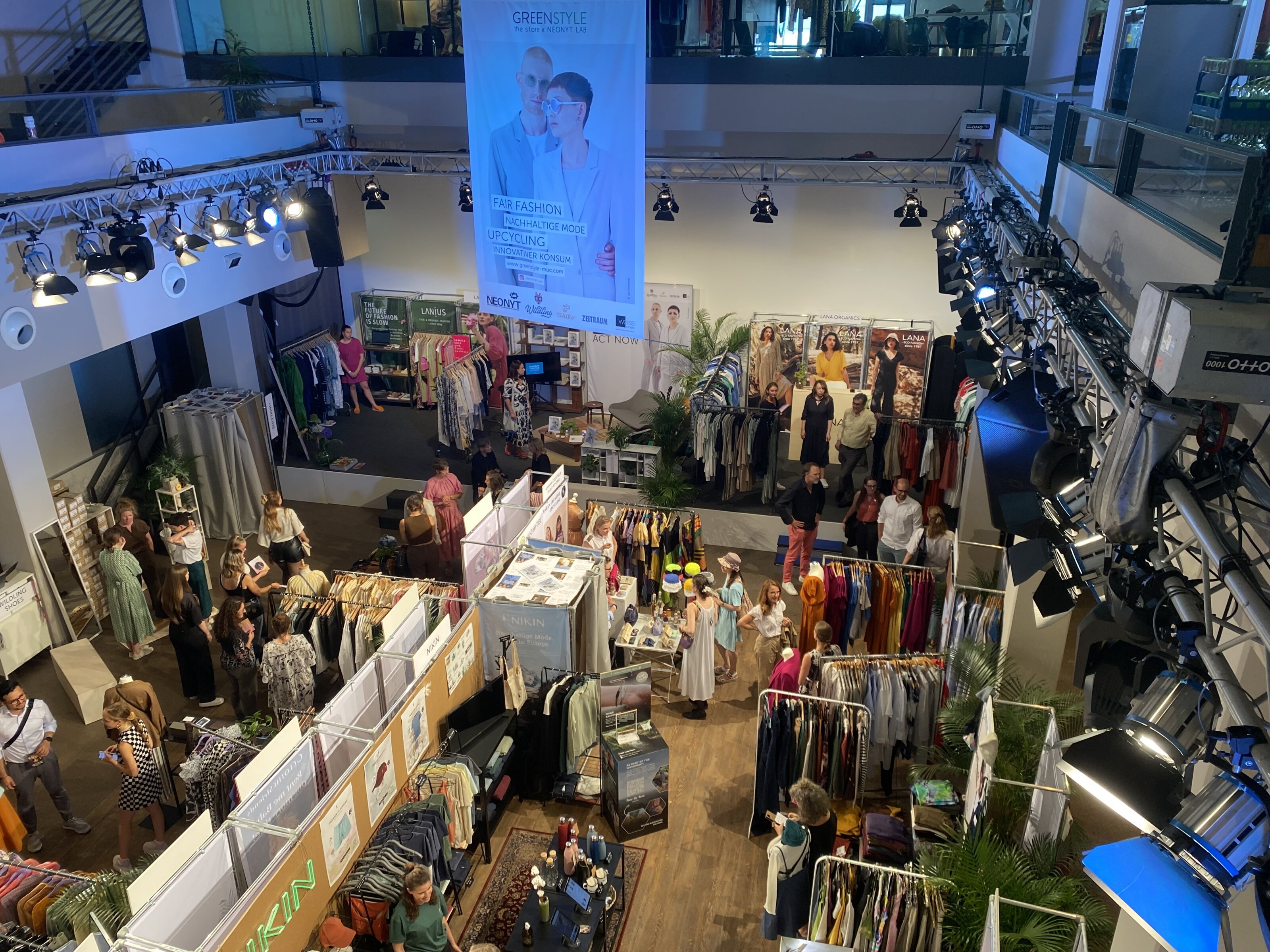 Modemesse mit Ständen, Kleiderstangen und Besuchern