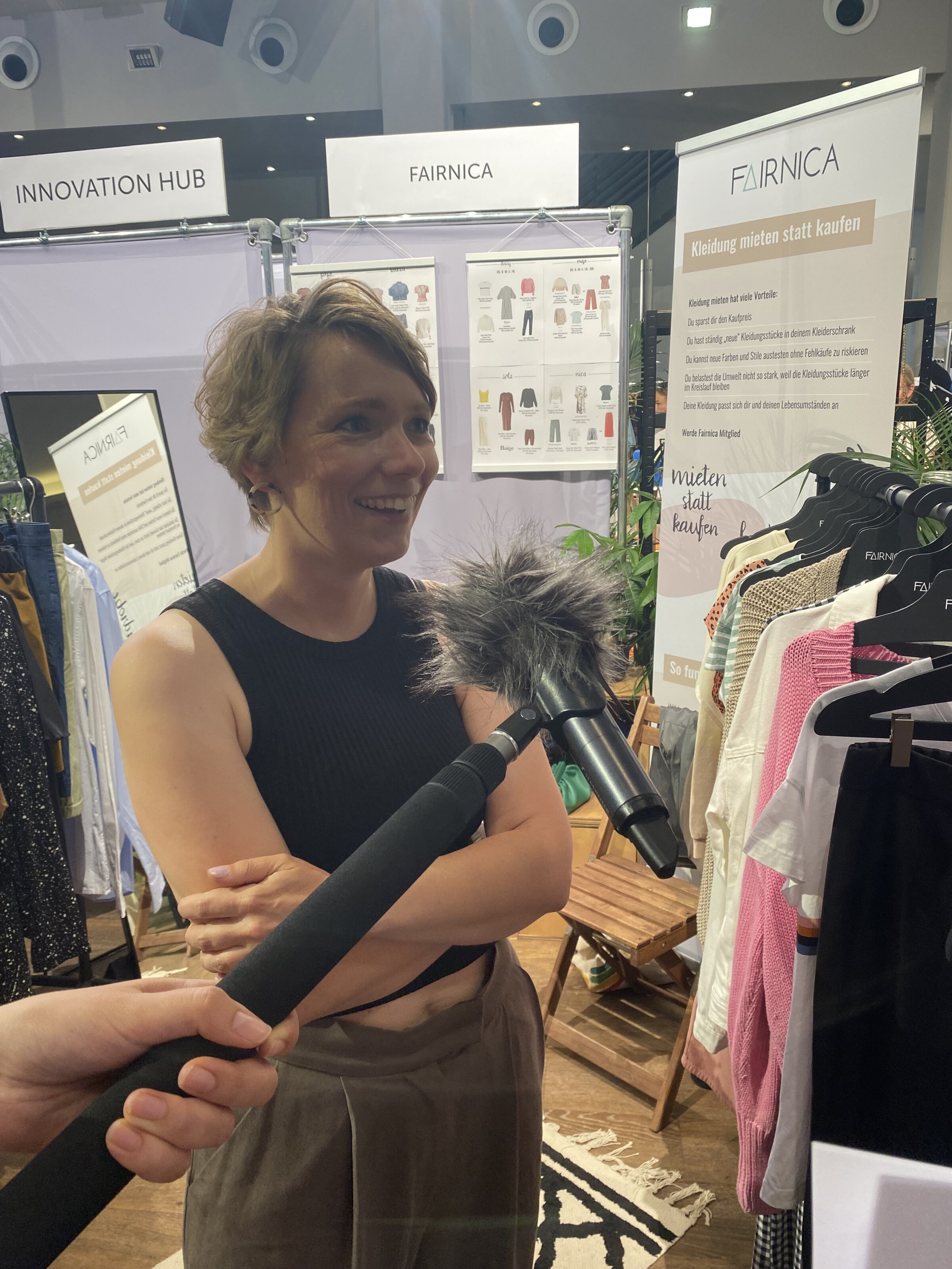 Interview mit Frau an FAIRNICA-Mode-Stand