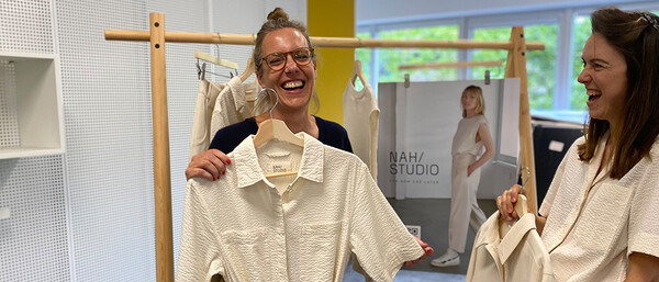 Zwei Frauen betrachten helle Kleidung im Studio