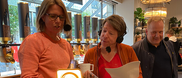 Drei Personen mit Headsets in einem Café